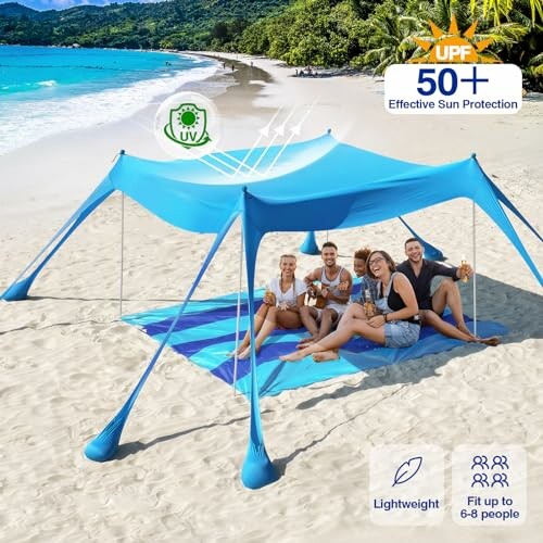 Group of people under a blue sunshade tent on a beach.