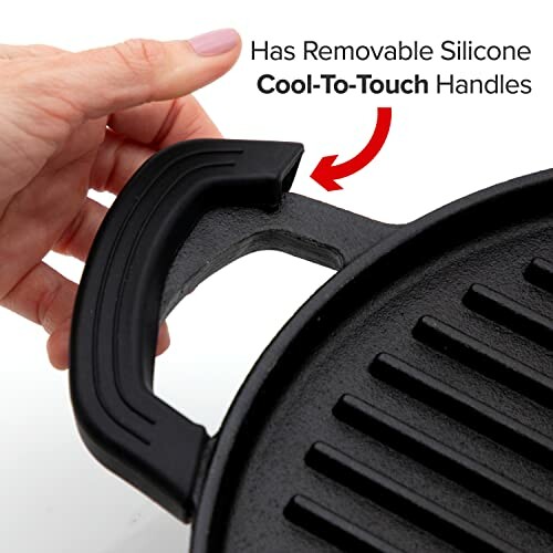 Hand holding a cast iron skillet with removable silicone handle.