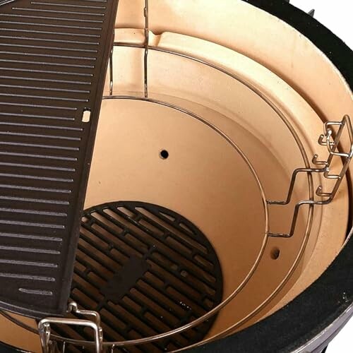Interior view of a ceramic grill with grates and hooks