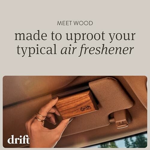 Hand installing Drift wood air freshener in car.