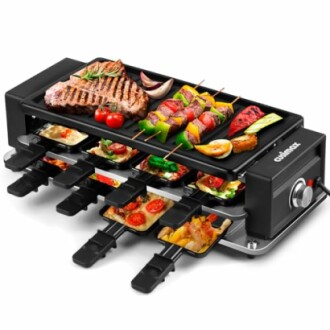 Electric grill with raclette trays cooking meat, vegetables, and cheese.