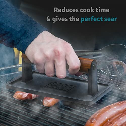 Hand using a grill press on sausages with steam rising