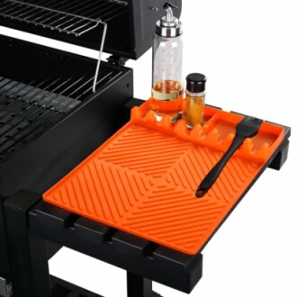 Orange grill side tray with cooking accessories and bottles.