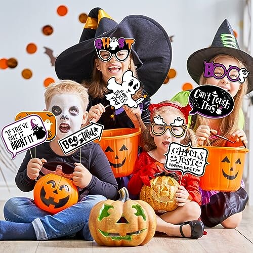 Children in Halloween costumes holding pumpkins and signs