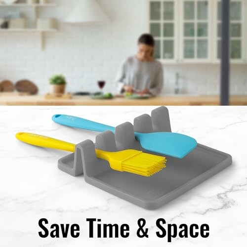 Gray utensil holder with blue spatula and yellow brush on kitchen counter.