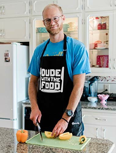 Man wearing apron cutting vegetables in the kitchen