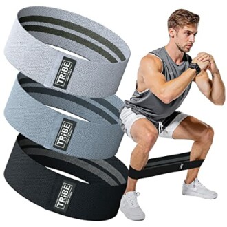 Man performing squat exercise with resistance bands in different colors.