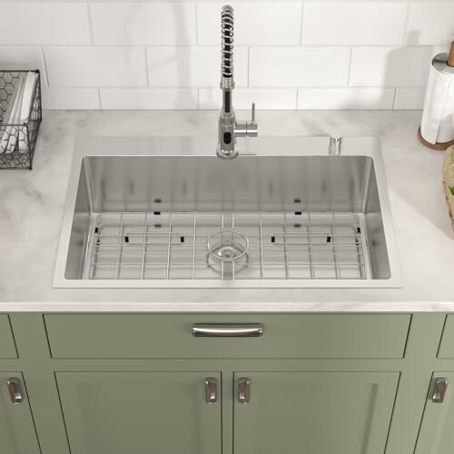 Stainless steel kitchen sink with grid and tall faucet
