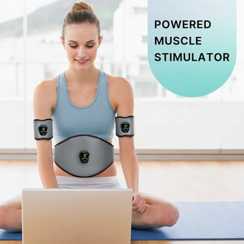 Woman using powered muscle stimulator while on laptop