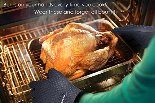Person using oven gloves to remove roast chicken from oven