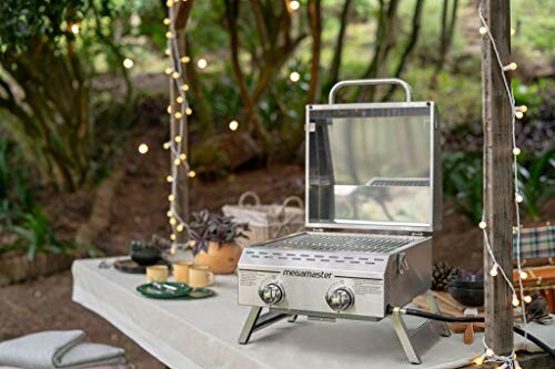 Portable grill on outdoor table with string lights