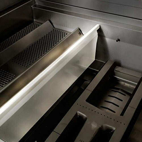 Close-up view of a stainless steel grill interior with grates and trays.